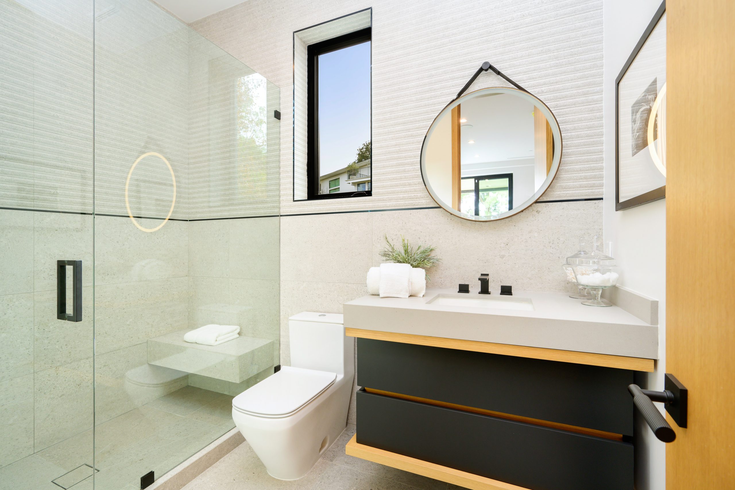 Bathroom with a sink, a toilet, a mirror, and shelves.